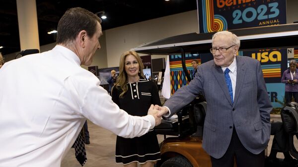 Warren Buffett and See's Candies President and CEO, Pat Egan, shake hands at the Berkshire Hathaway Shareholder Meeting on Friday, May 5, 2023 in Omaha, Nebraska. - Sputnik International