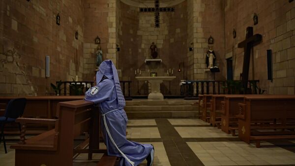 A penitent prays inside of a church during Holy Week Ensogado procession, in Sietamo, northern Spain, Thursday, April 6, 2023. - Sputnik International