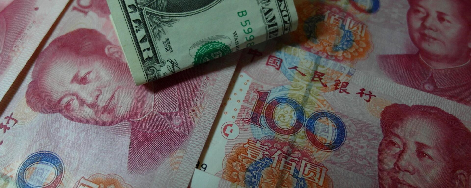 Yuan banknotes and US dollars are seen on a table in Yichang, central China's Hubei province on August 14, 2015 - Sputnik International, 1920, 11.05.2023