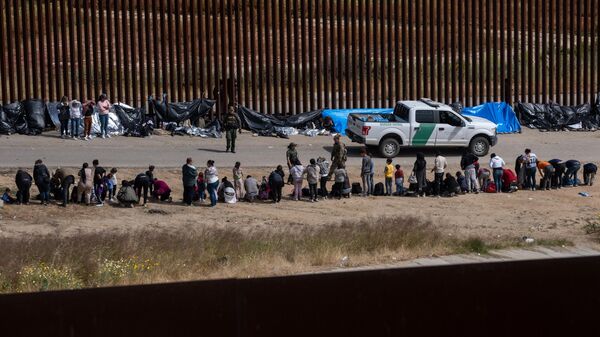 Migrants wait to be processed by United States authorities on the US side of the US-Mexico border, seen from Tijuana, Baja California state, Mexico, on May 11, 2023. - Sputnik International