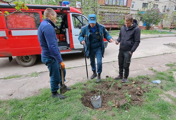 DPR&#x27;s EMERCOM officers near a fragment of Uragan multiple rocket launcher munition that fell in a residential area of Gorlovka after shelling by the Ukrainian Armed Forces - Sputnik International