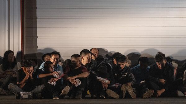 Migrants wait for a bus to take them to a processing center after they turned themselves over to US Border Patrol agents after crossing over from Mexico in Fronton, Texas on May 12, 2023. - Sputnik International