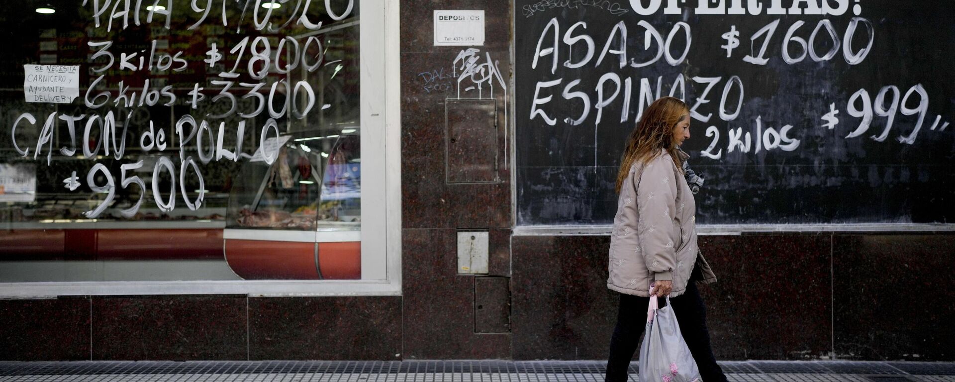 A woman walks by a meat market in Buenos Aires, Argentina, Thursday, May 11, 2023. According to a recent World Bank Food Security report, Argentina has seen a 107% annual inflation rate in food prices. - Sputnik International, 1920, 23.10.2023