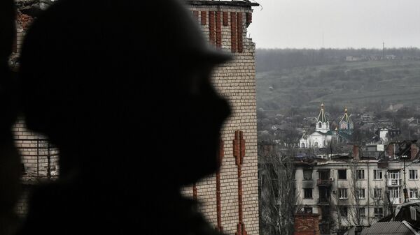 A service member of Russia's private military company Wagner Group inspects a building in Artemovsk, also known as Bakhmut, as Russia's military operation in Ukraine continues, Donetsk People's Republic, Russia. - Sputnik International