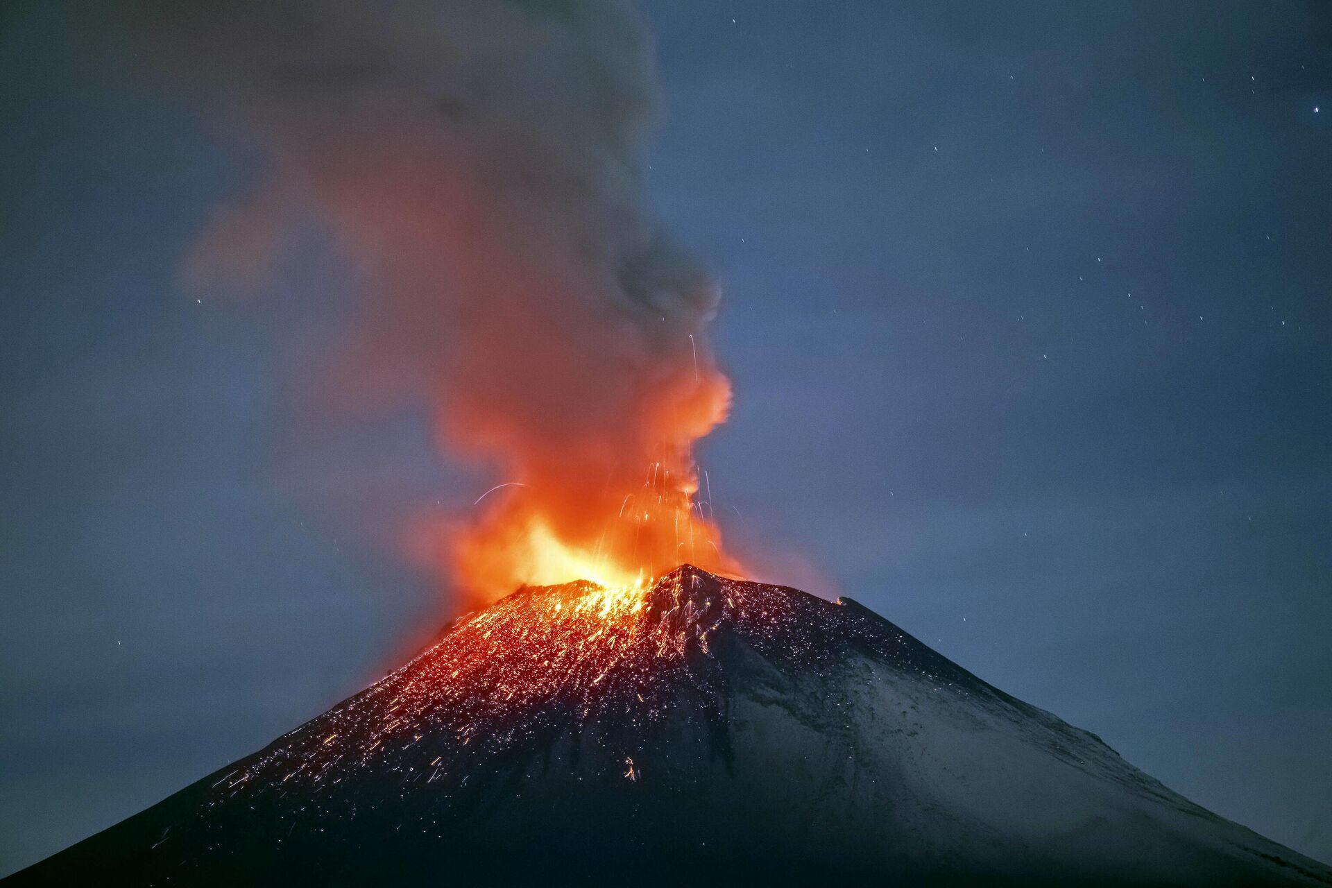 Incandescent materials, ash and smoke are spewed from the Popocatepetl volcano as seen from thr Santiago Xalitzintla community, state of Puebla, Mexico, on May 22, 2023. Mexican authorities on May 21 raised the warning level for the Popocatepetl volcano to one step below red alert, as smoke, ash and molten rock spewed into the sky posing risks to aviation and far-flung communities below. Sunday's increased alert level -- to yellow phase three -- comes a day after two Mexico City airports temporarily halted operations due to falling ash. - Sputnik International, 1920, 23.05.2023