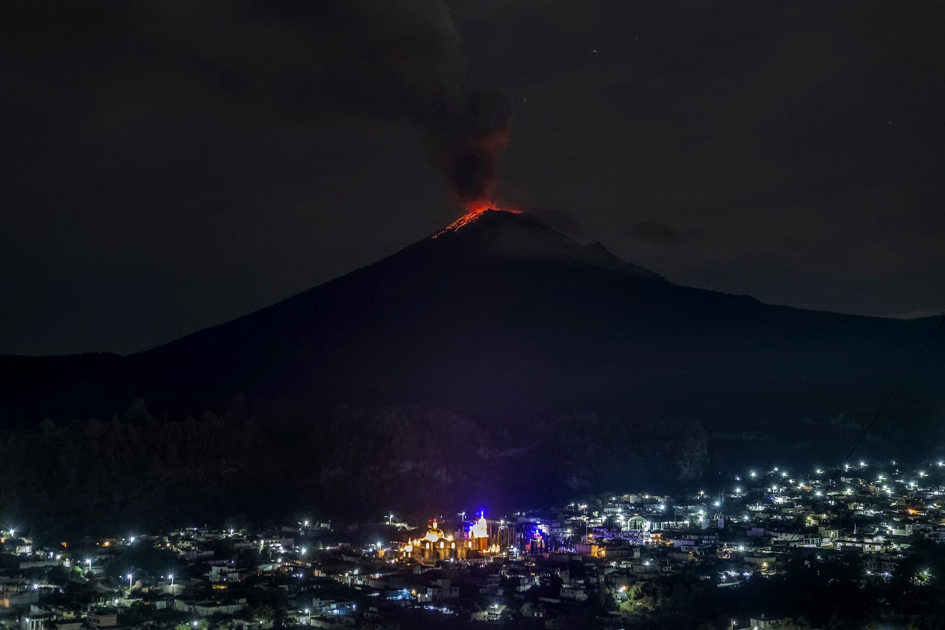 The Popocatepetl Volcano spews ash and smoke as seen from thr Santiago Xalitzintla community, state of Puebla, Mexico, on May 22, 2023. Mexican authorities on May 21 raised the warning level for the Popocatepetl volcano to one step below red alert, as smoke, ash and molten rock spewed into the sky posing risks to aviation and far-flung communities below. Sunday's increased alert level -- to yellow phase three -- comes a day after two Mexico City airports temporarily halted operations due to falling ash. - Sputnik International, 1920, 23.05.2023