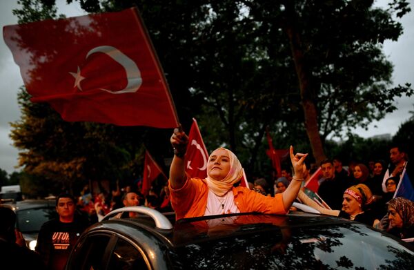 A supporter of incumbent President Recep Tayyip Erdogan carrying a flag in front of the office of the ruling party in Istanbul. - Sputnik International