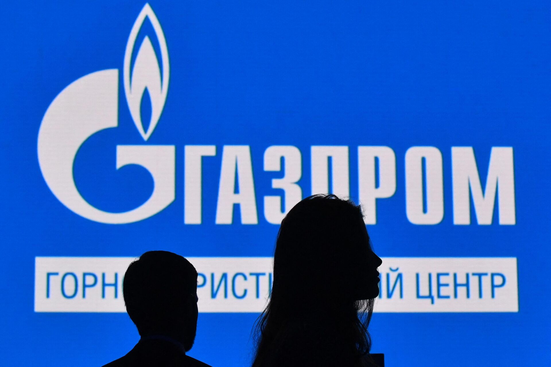 Participants walk in front of a large screen displaying the logo of Russia's energy giant Gazprom during the St. Petersburg International Gas Forum (SPIGF) in Saint Petersburg on September 15, 2022. - Sputnik International, 1920, 31.05.2023