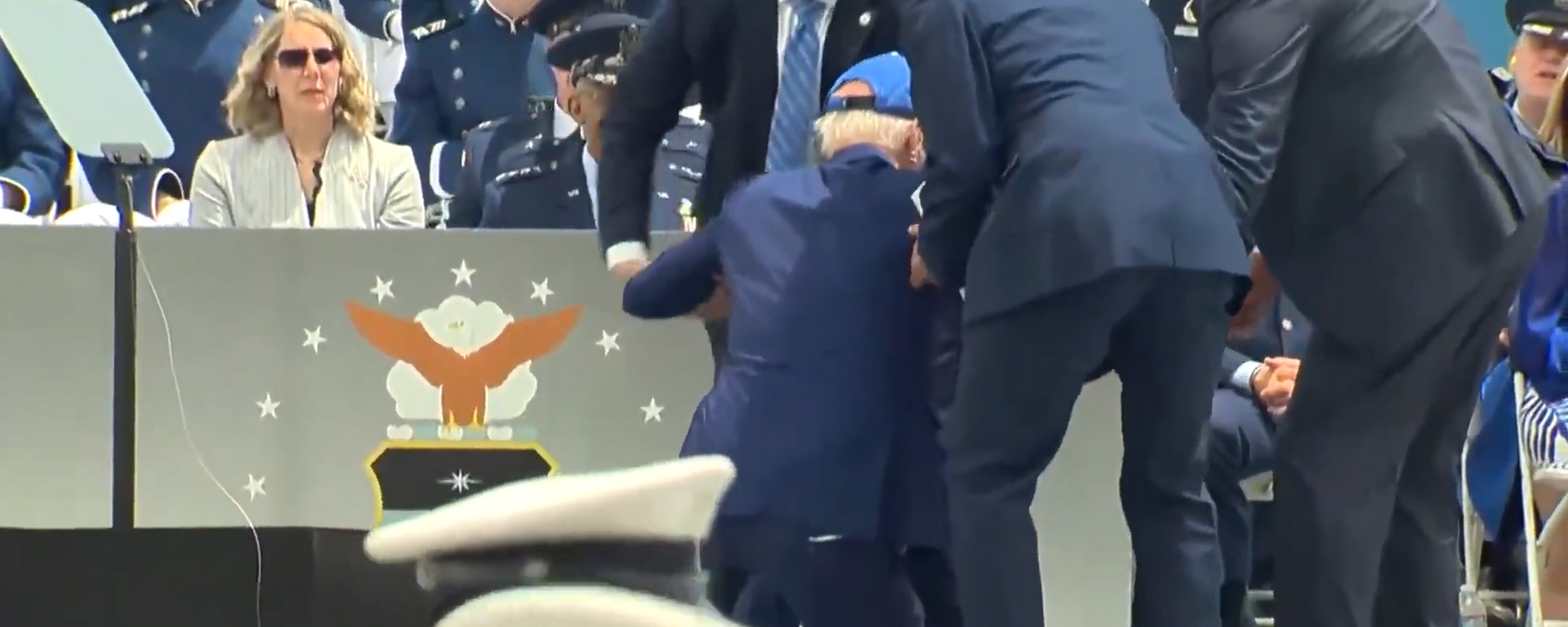 این تصویر لحظه ای را به تصویر می کشد که جو بایدن، رئیس جمهور ایالات متحده، در حین مراسم اهدای جوایز در آکادمی نیروی هوایی ایالات متحده در کلرادو روی صحنه سقوط می کند.  - اسپوتنیک بین المللی، 1920، 01.06.2023