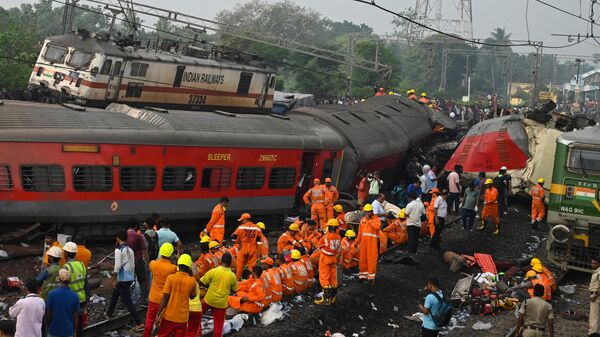 Rescue workers gather around damaged carriages at the accident site of a three-train collision near Balasore, about 200 km (125 miles) from the state capital Bhubaneswar in the eastern state of Odisha, on June 3, 2023. At least 288 people were killed and more than 850 injured in a horrific three-train collision in India, officials said on June 3, the country's deadliest rail accident in more than 20 years. (Photo by Dibyangshu SARKAR / AFP) - Sputnik International