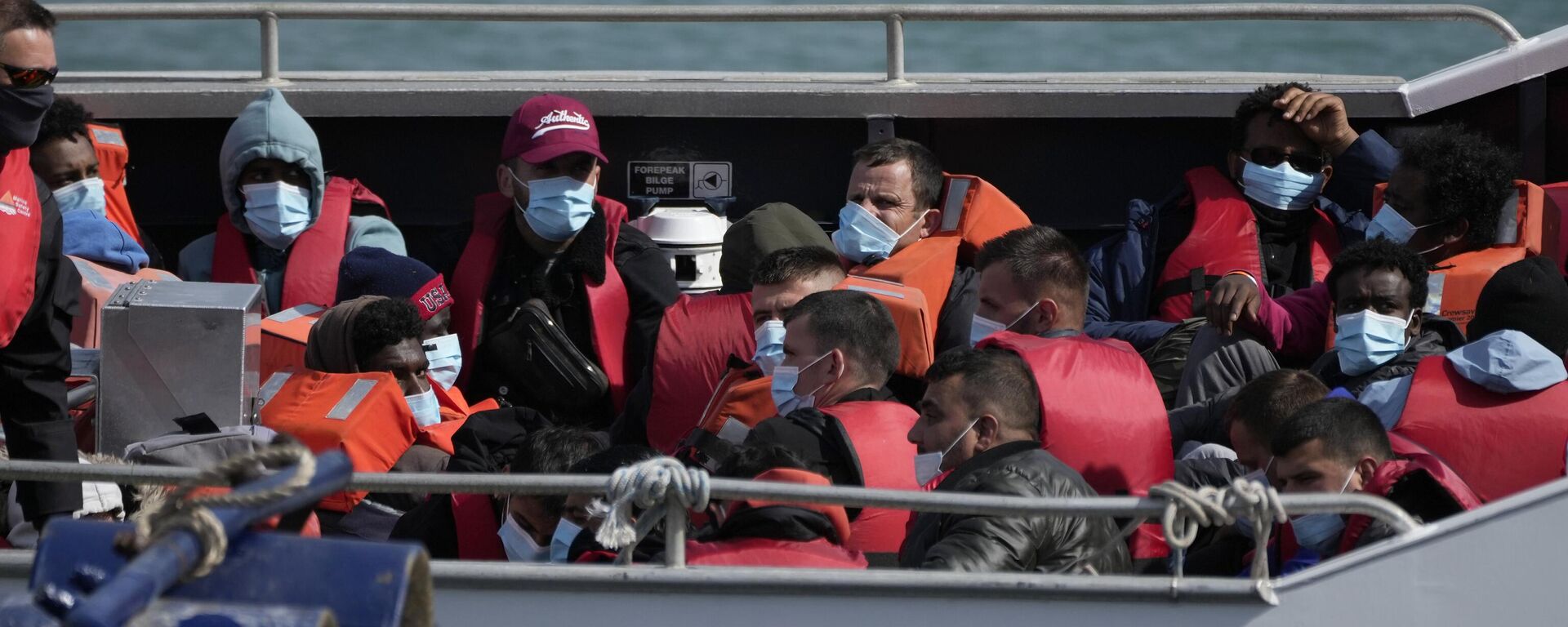 People thought to be migrants who undertook the crossing from France in small boats and were picked up in the Channel, wait to be disembarked from a British border force vessel, in Dover, south east England - Sputnik International, 1920, 05.06.2023