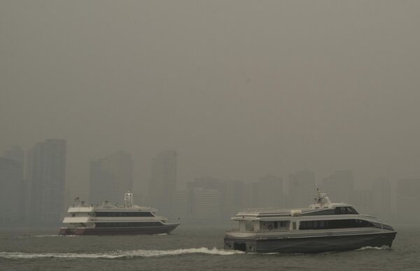 Buildings in Jersey City, NJ, are partially covered by smoke from Canadian wildfires as ferries travel up the Hudson River, seen from the Manhattan borough of New York on Tuesday, June 6, 2023. - Sputnik International