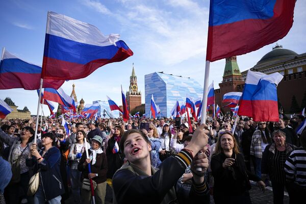 Thousands of people wave Russian national flags as they gather on Red Square to watch a concert dedicated to the Russia Day in Moscow.  - Sputnik International