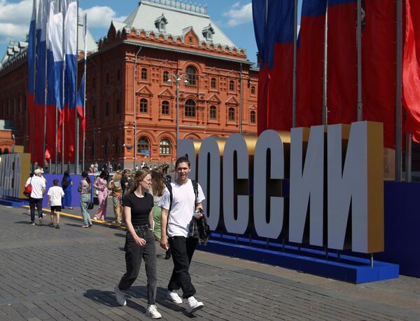 People stroll across Manezhnaya Square in Moscow on June 9, which had already been decorated for the Russia Day celebrations. - Sputnik International