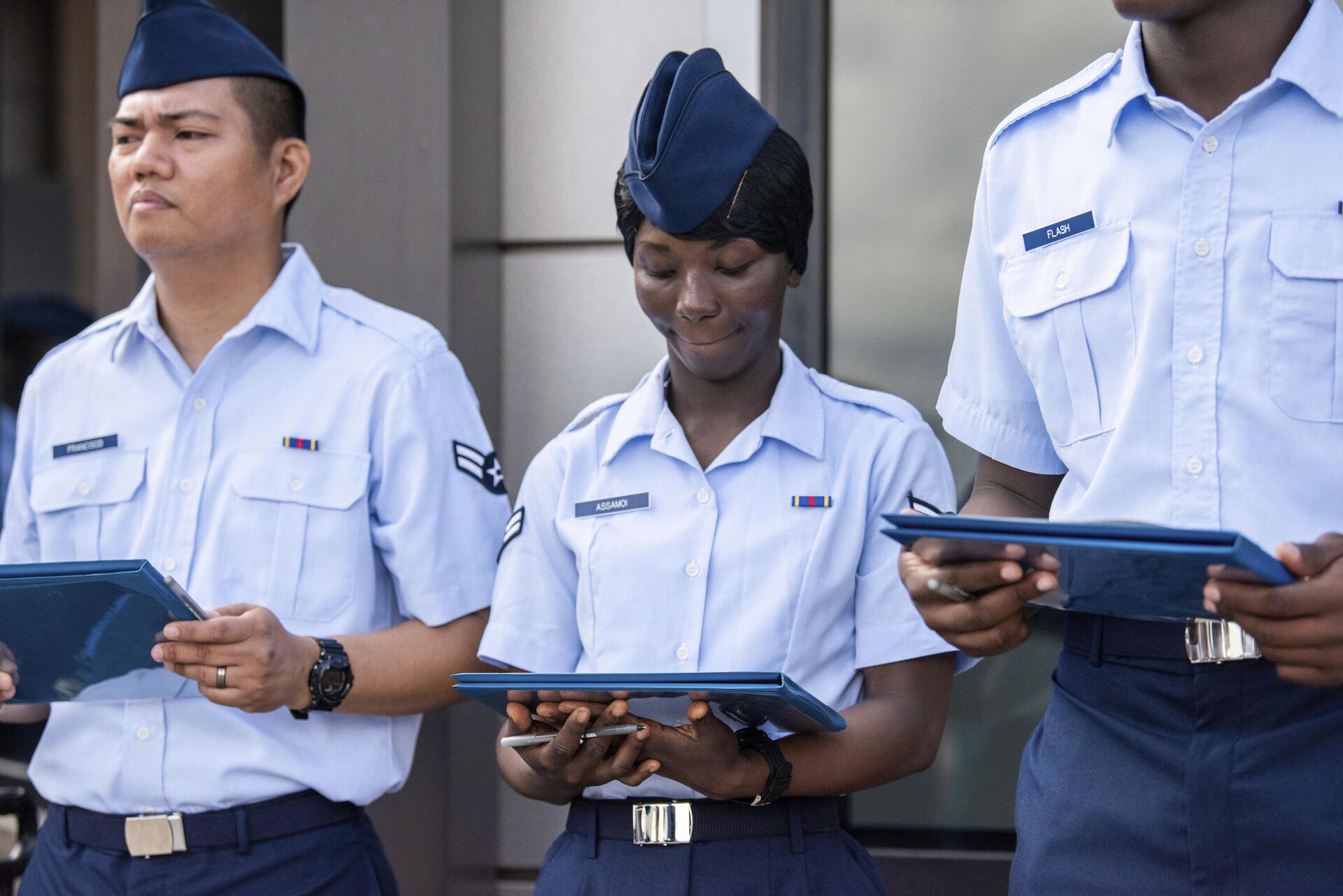 Airman 1st Class Joshua Fancisco, from the Philippines, left, Airman 1st Class D'elbrah Assamoi, from Cote D'Ivoire, center, and Airman 1st Class Jordan Flash, from Jamaica, looks at their U.S. Certificate of Citizenship after signing it following the Basic Military Training Coin Ceremony on April 26, 2023, at Joint Base San Antonio-Lackland, Texas - Sputnik International, 1920, 12.06.2023