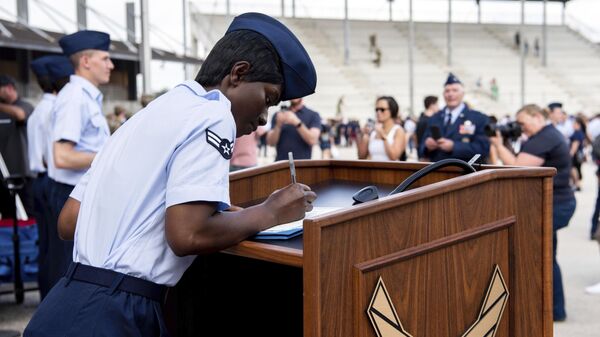 Airman 1st Class D'elbrah Assamoi, from Cote D'Ivoire, signs her US certificate of citizenship after the Basic Military Training Coin Ceremony at Joint Base San Antonio-Lackland, in San Antonio, April 26, 2023 - Sputnik International