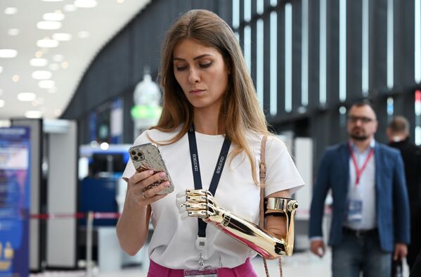 A participant scrolling through her mobile phone at the Expoforum Convention and Exhibition Center. - Sputnik International