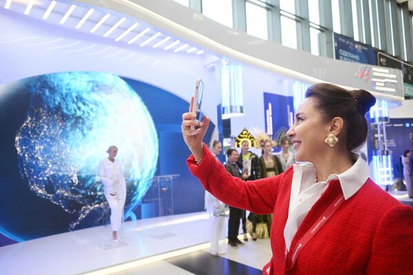 A forum participant taking a selfie by the stand of the Russian Export Center (REC). - Sputnik International