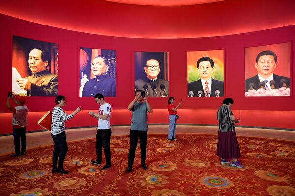 A group of people take pictures in front of portraits of (L to R) late Chinese Communist Party Chairman Mao Zedong and former Chinese leaders Deng Xiaoping, Jiang Zemin, Hu Jintao, and current President Xi Jinping at an exhibition marking the country&#x27;s achievements over the past 70 years, ahead of the 70th anniversary of the founding of the People&#x27;s Republic of China, in Beijing. - Sputnik International
