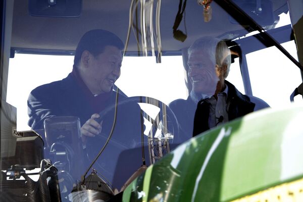 Xi Jinping (L) talks to farmer Rick Kimberley as they sit in the cab of a tractor while touring his family farm in Maxwell, Iowa. - Sputnik International