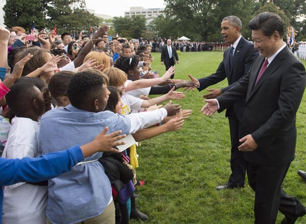 US President Barack Obama and Chinese President Xi Jinping greet school children during a state arrival ceremony on the South Lawn of the White House in Washington, DC. - Sputnik International