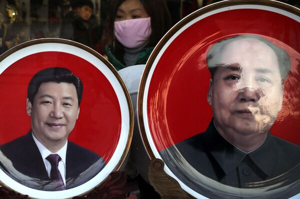 A woman looks at souvenir plates bearing images of Chinese President Xi Jinping, left, and late Chinese leader Mao Zedong on display for sale at a shop near Tiananmen Square in Beijing. - Sputnik International