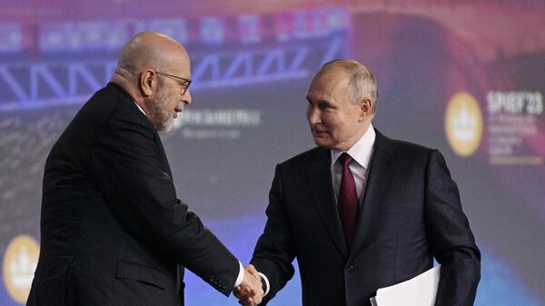 Russian President Vladimir Putin shakes hands with veteran political scientist and former president and CEO of the Center for the National Interest Dimitri Simes at the St. Petersburg International Economic Forum. Friday, June 16, 2023. - Sputnik International