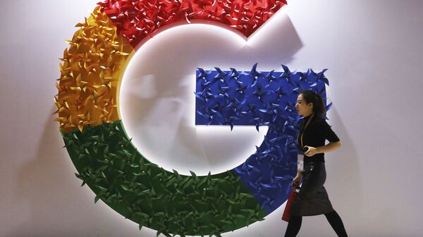 A woman walks past the logo for Google at the China International Import Expo in Shanghai, Nov. 5, 2018. - Sputnik International