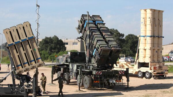 Israeli soldiers walk near an Iron Dome defence system (L), a surface-to-air missile (SAM) system, the MIM-104 Patriot (C), and an anti-ballistic missile the Arrow 3 (R) during Juniper Cobra's joint exercise press briefing at Hatzor Israeli Air Force Base in central Israel, on February 25, 2016 - Sputnik International