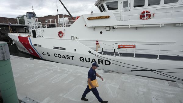 The U.S. Coast Guard Cutter Warren Deyampert is docked as a member of the Coast Guard walks past - Sputnik International