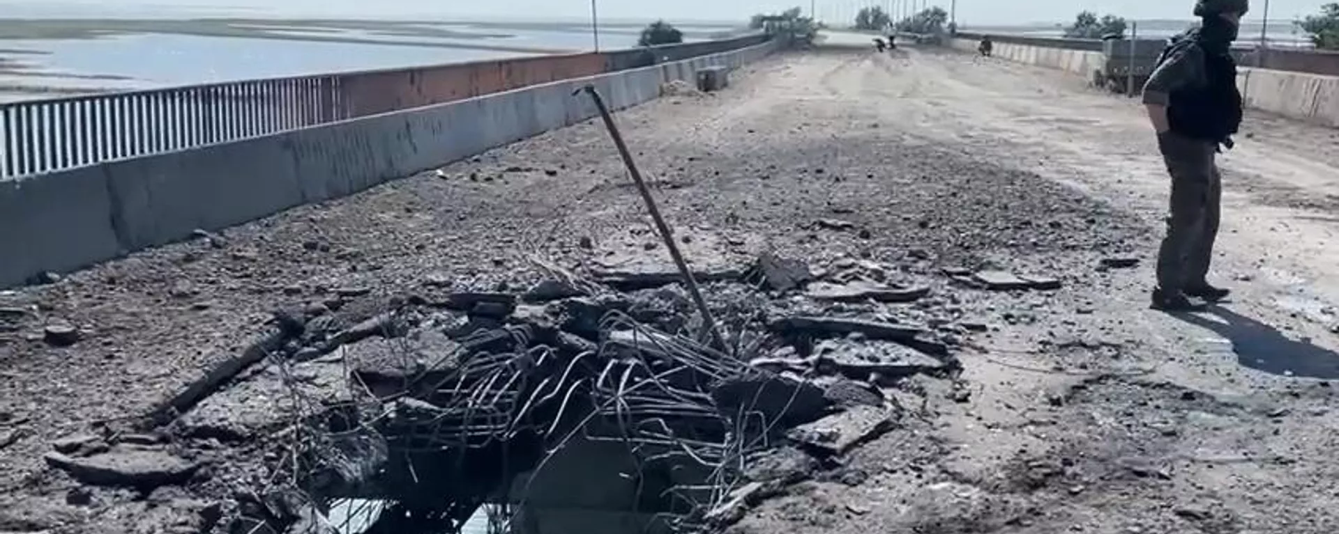 A Russian Investigative Committee serviceman stands on a bridge damaged during the Ukrainian armed forces' attack, on the administrative border between the Kherson Region and the Crimea near the village of Chongar, Crimea, Russia. - Sputnik International, 1920, 22.06.2023