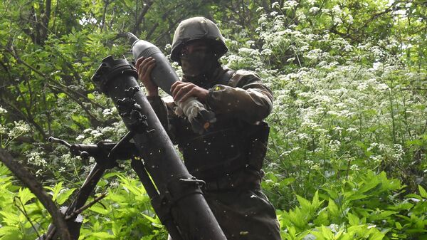 A Russian serviceman of a mortar unit charges a mortar, in the course of Russia's military operation in Ukraine, in Lugansk People's Republic, Russia. - Sputnik International