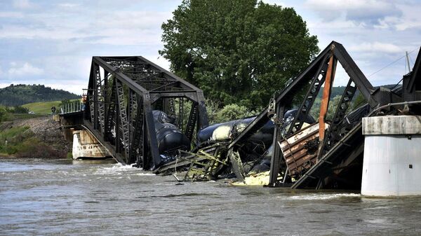 Several train cars are immersed in the Yellowstone River after a bridge collapse near Columbus, Mont., on Saturday, June 24, 2023. The bridge collapsed overnight, causing a train that was traveling over it to plunge into the water below.  - Sputnik International