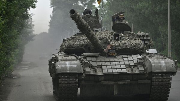 Ukrainian servicemen ride on a tank in Donetsk region on June 28, 2023. - Sputnik International