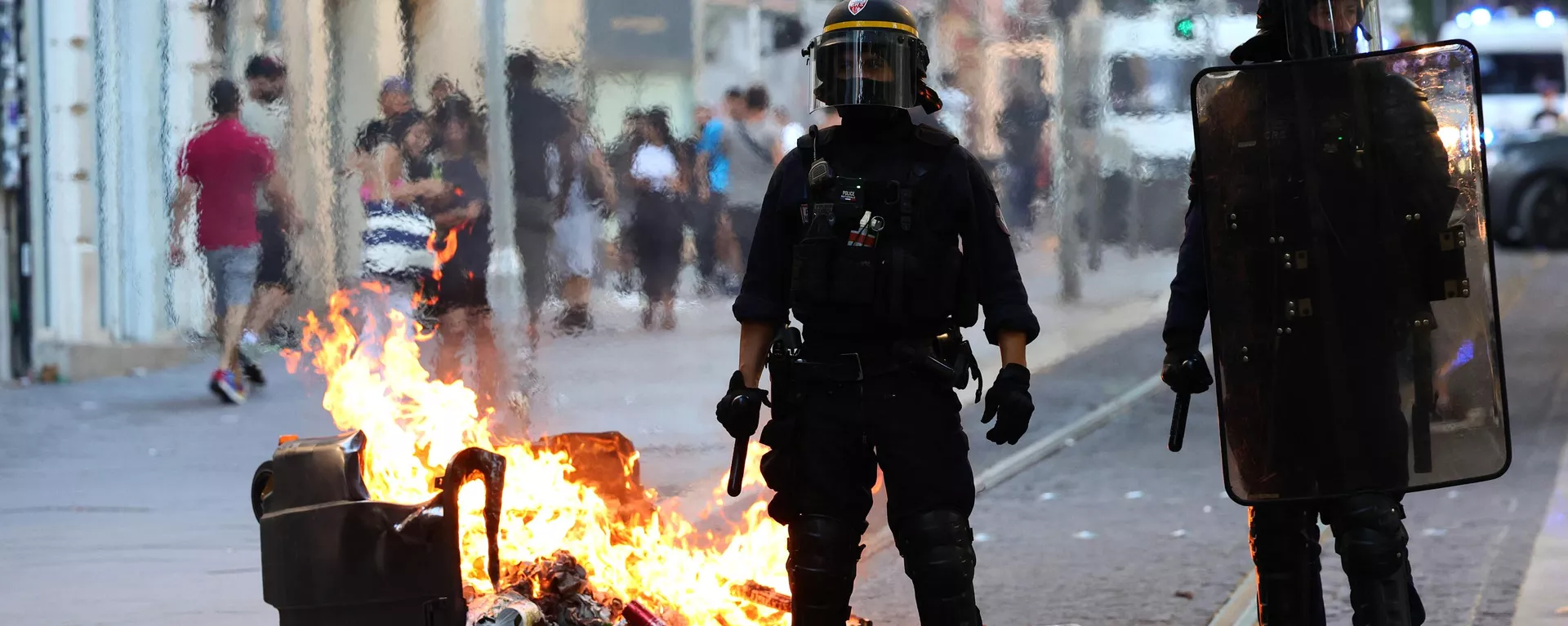French riot police officers stand guard next to a burnt out trash bin during a demonstration against police in Marseille, southern France on July 1, 2023. - Sputnik International, 1920, 02.07.2023