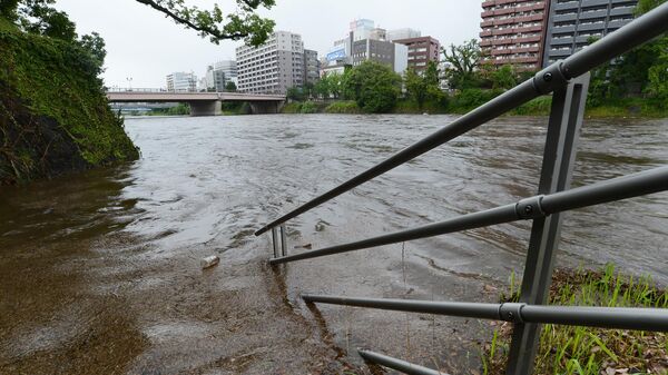 Part of a handrail sits submerged after the Shirakawa River in the city of Kumamoto, Kumamoto Prefecture, rose following heavy rains across the Japanese island of Kyushu on June 30, 2023. - Sputnik International