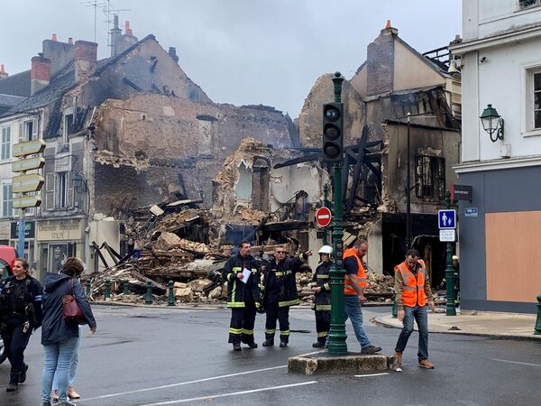 Emergency personnel survey the scene of a burnt out building - which housed a pharmacy - in Montargis, some 100kms south of Paris.  - Sputnik International