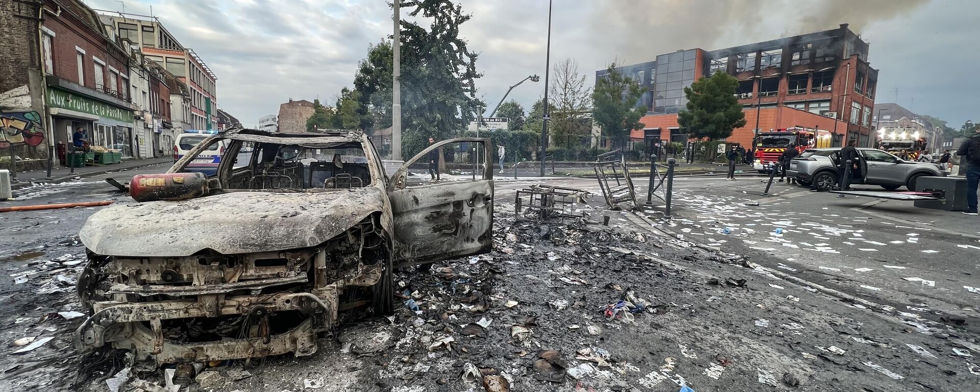 Сгоревший автомобиль и сгоревшее зданиние после протестов во французском городе Рубе - Sputnik International, 1920, 03.07.2023