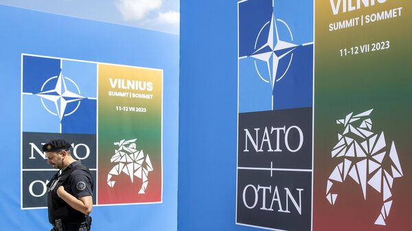 A security guard walks in front of a banner outside the venue of the NATO summit in Vilnius, Lithuania, Sunday, July 9, 2023. - Sputnik International