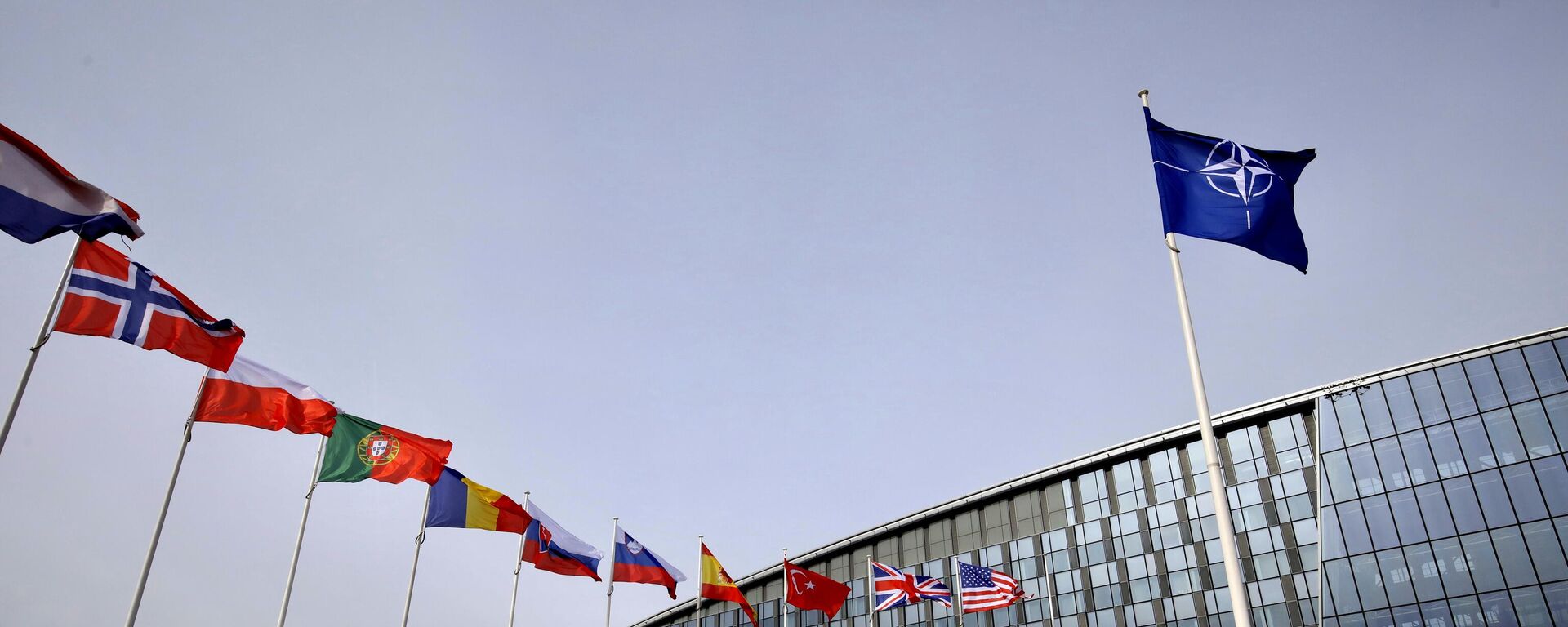Flags of Alliance members flap in the wind outside NATO headquarters in Brussels, Friday, Feb. 28, 2020. (AP Photo/Olivier Matthys) - Sputnik International, 1920, 12.07.2023