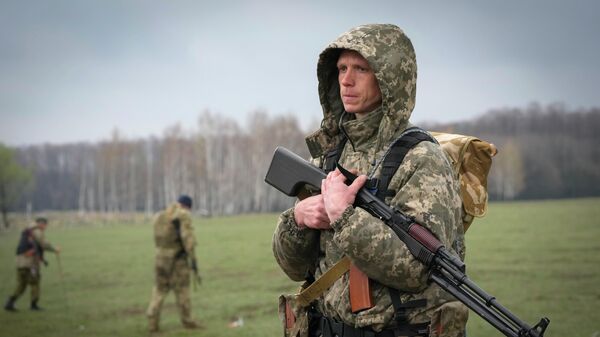 A Ukrainian soldier stands in the fields at the village of Berezovka, Ukraine, Thursday, April 21, 2022. - Sputnik International