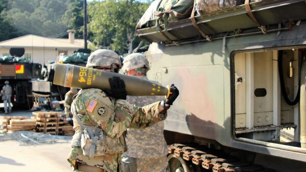 A US soldier carries a 155mm Base Burn Dual Purpose Improved Conventional Munition round, weighing more than 100 pounds, to a M992 Field Artillery Support Vehicle during the exercise. File photo. - Sputnik International