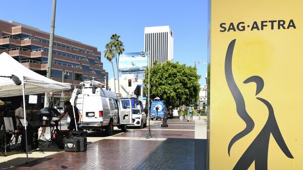 A sign for SAG-AFTRA, the US labor union that represents film and television actors, singers, and other performers, is seen as members of the media gather outside the SAG-AFTRA building during contract negotiations in Los Angeles, California, on July 13, 2023. - Sputnik International