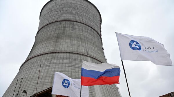 A Russian national flag and flags with the logo of Rosatom flutters at the construction site of a cooling tower at the Kursk II nuclear power plant near the village of Makarovka outside Kurchatov, Kursk region - Sputnik International