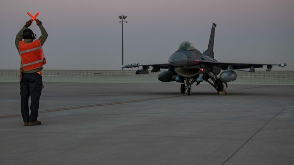 In this handout photo from the U.S. Air Force, an airman guides an F-16 Fighting Falcon during training at Al-Udeid Air Base, Qatar in January 2022. File photo. - Sputnik International