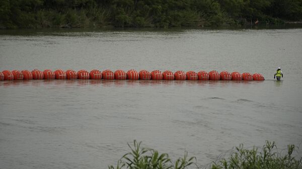 Workers continue to deploy large buoys to be used as a border barrier on the Rio Grande in Eagle Pass, Texas, Wednesday, July 12, 2023. - Sputnik International