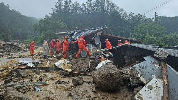 Rescue workers search for people in a house collapsed after a landslide caused by heavy rain in Yeongju, South Korea, Saturday, July 15, 2023 - Sputnik International