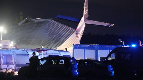 The tail of a Cessna 208 plane sticks out of a hangar after it crashed there in bad weather killing several people and injuring others, at a sky-diving centre in Chrcynno, central Poland, on Monday, July 17, 2023.  - Sputnik International