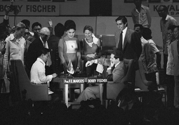World chess champion Bobby Fischer, on the right, and Philippine President Ferdinand Marcos, on the left left, play a ceremonial game of chess during the opening of the Philippines International Chess Tournament in M anila, October 16, 1973. In the background are the president&#x27;s wife Imelda and Christina Ford. - Sputnik International