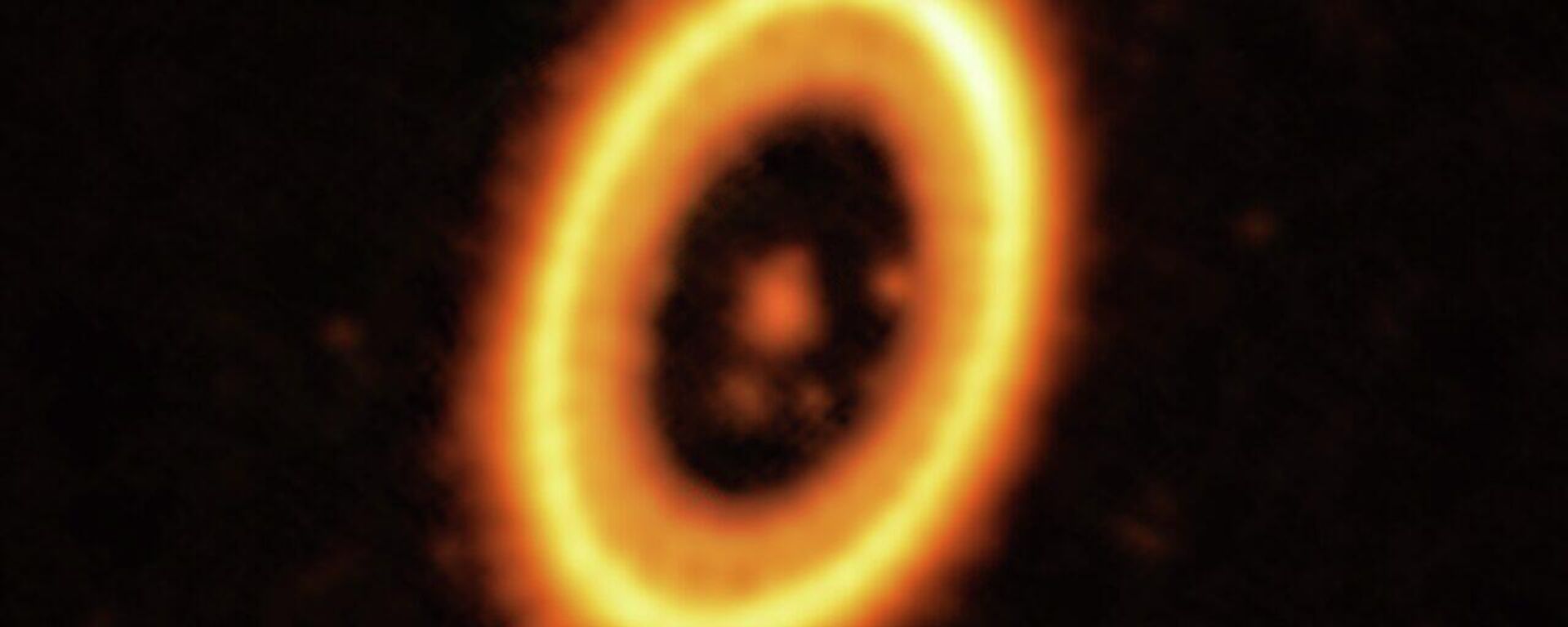 This image, taken with the Atacama Large Millimeter/submillimeter Array (ALMA), in which ESO is a partner, shows the young planetary system PDS 70, located nearly 400 light-years away from Earth. The system features a star at its centre, around which the planet PDS 70b is orbiting. On the same orbit as PDS 70b, astronomers have detected a cloud of debris that could be the building blocks of a new planet or the remnants of one already formed. The ring-like structure that dominates the image is a circumstellar disc of material, out of which planets are forming. There is in fact another planet in this system: PDS 70c, seen at 3 o’clock right next to the inner rim of the disc. - Sputnik International, 1920, 20.07.2023